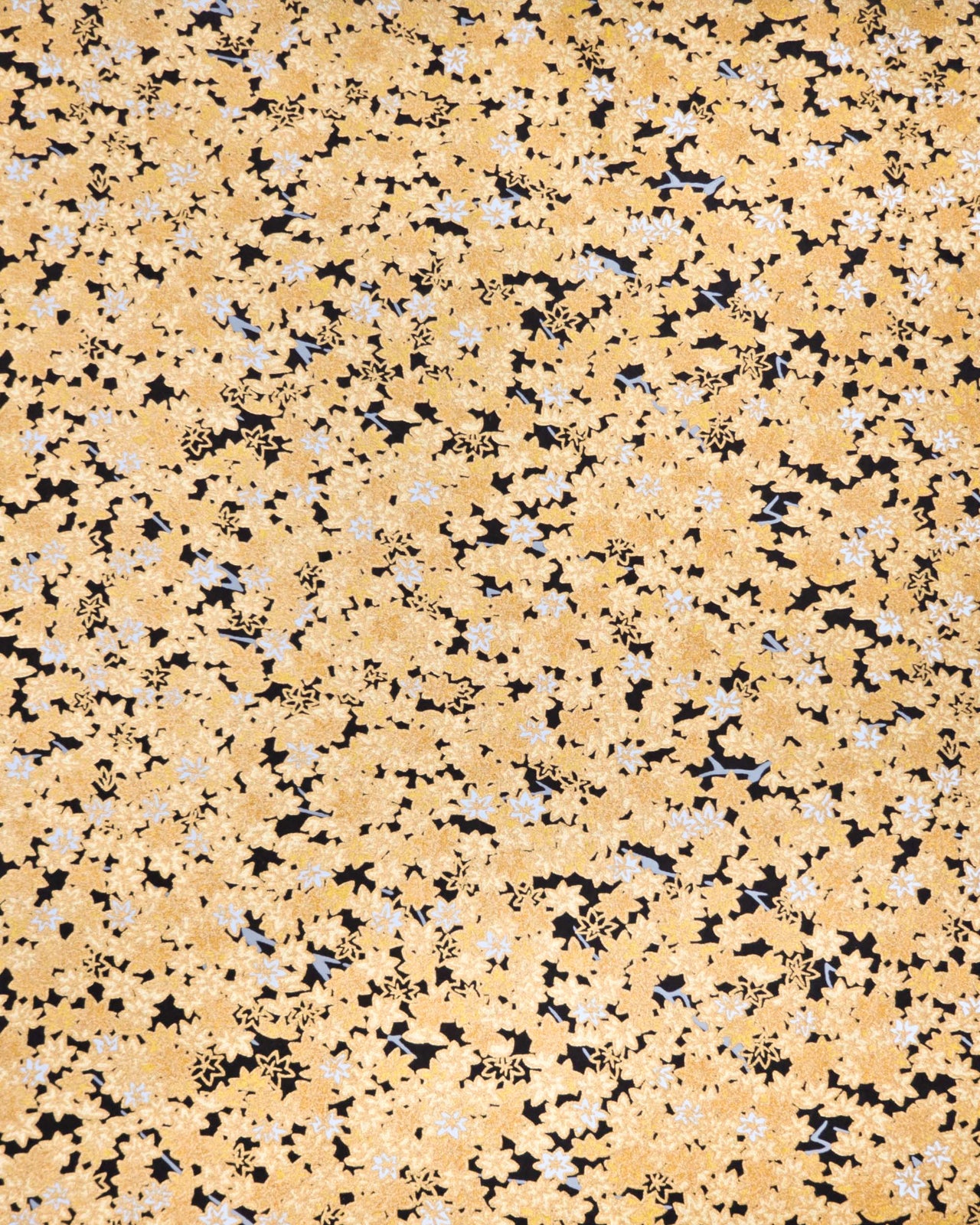 Japanese chiyogami paper featuring small gold and white momiji (maple leaves) on a black background with metallic gold details.