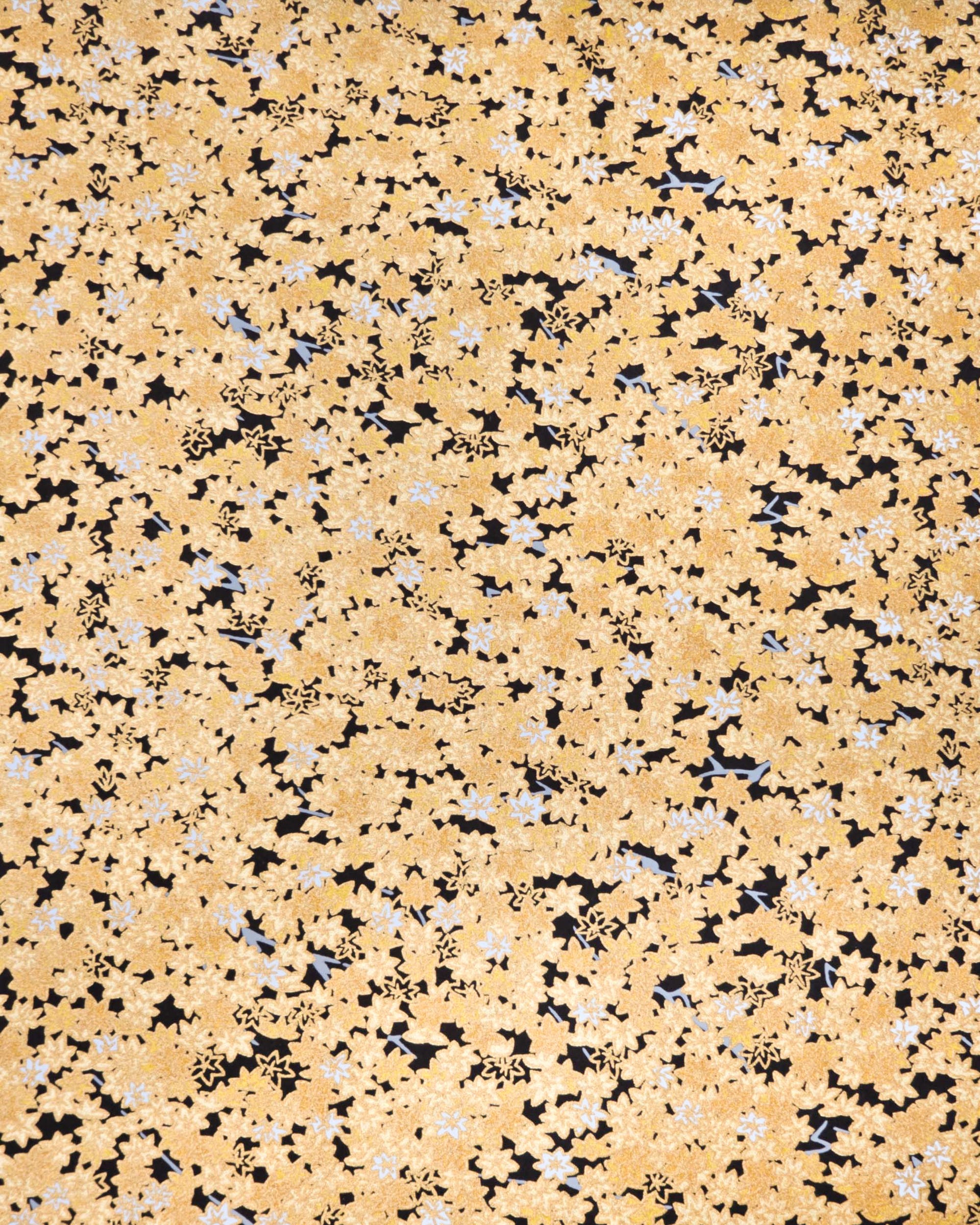 Japanese chiyogami paper featuring small gold and white momiji (maple leaves) on a black background with metallic gold details.
