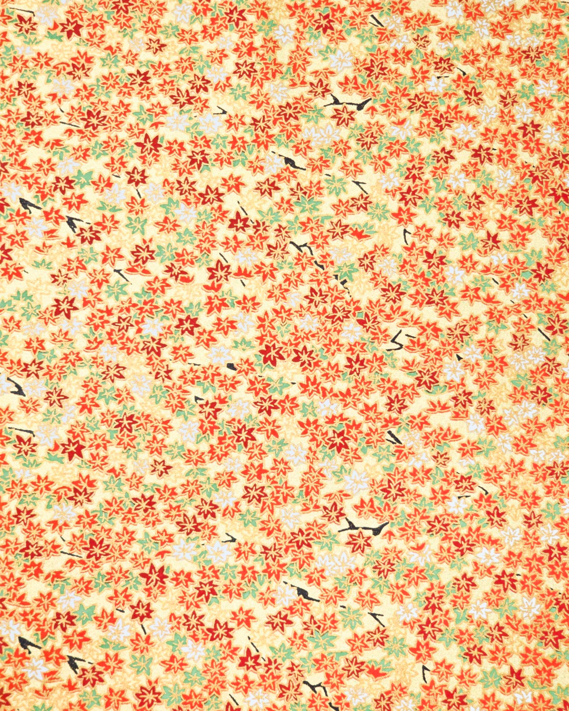 Japanese chiyogami paper featuring small red, green, and white momiji (maple leaves) on a gold background with metallic gold details.