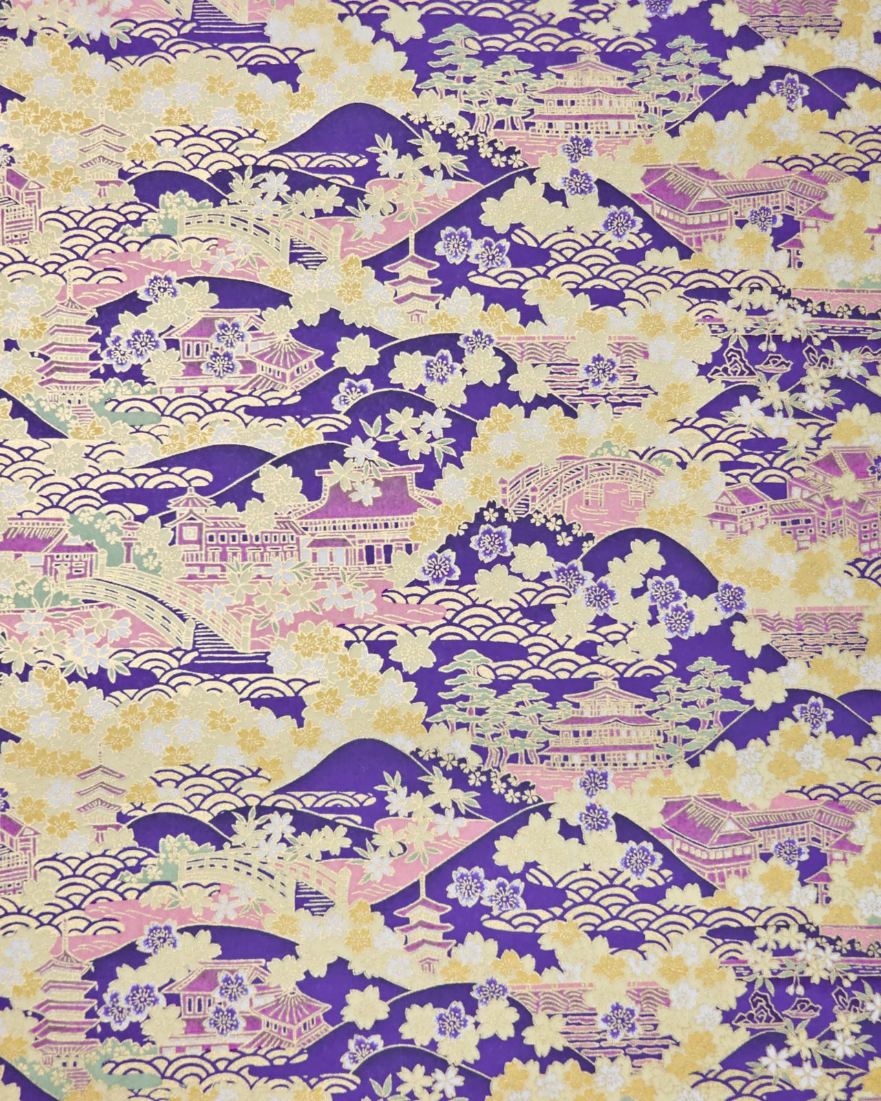 Japanese chiyogami paper featuring a traditional Japanese landscape with pagodas, temples, bridges, mountains, cherry blossoms, pine trees, and seigaiha (wave crests) patterns in yellow, pink, lavender, and mint green on a deep purple background with metallic gold details.