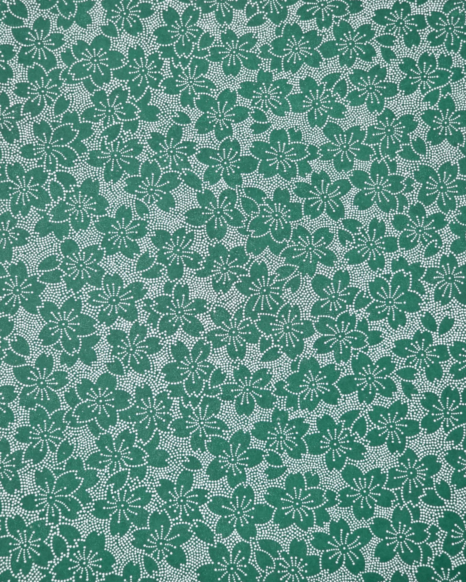 Japanese chiyogami paper featuring white pointillistic cherry blossoms on a dark green background.