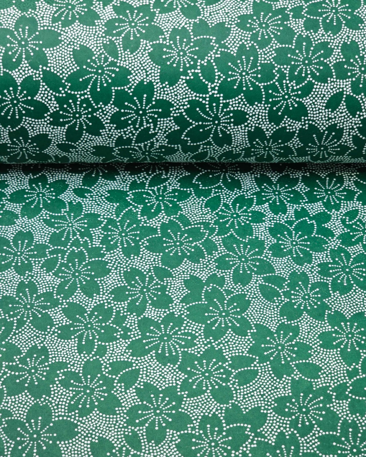 Japanese chiyogami paper featuring white pointillistic cherry blossoms on a dark green background.