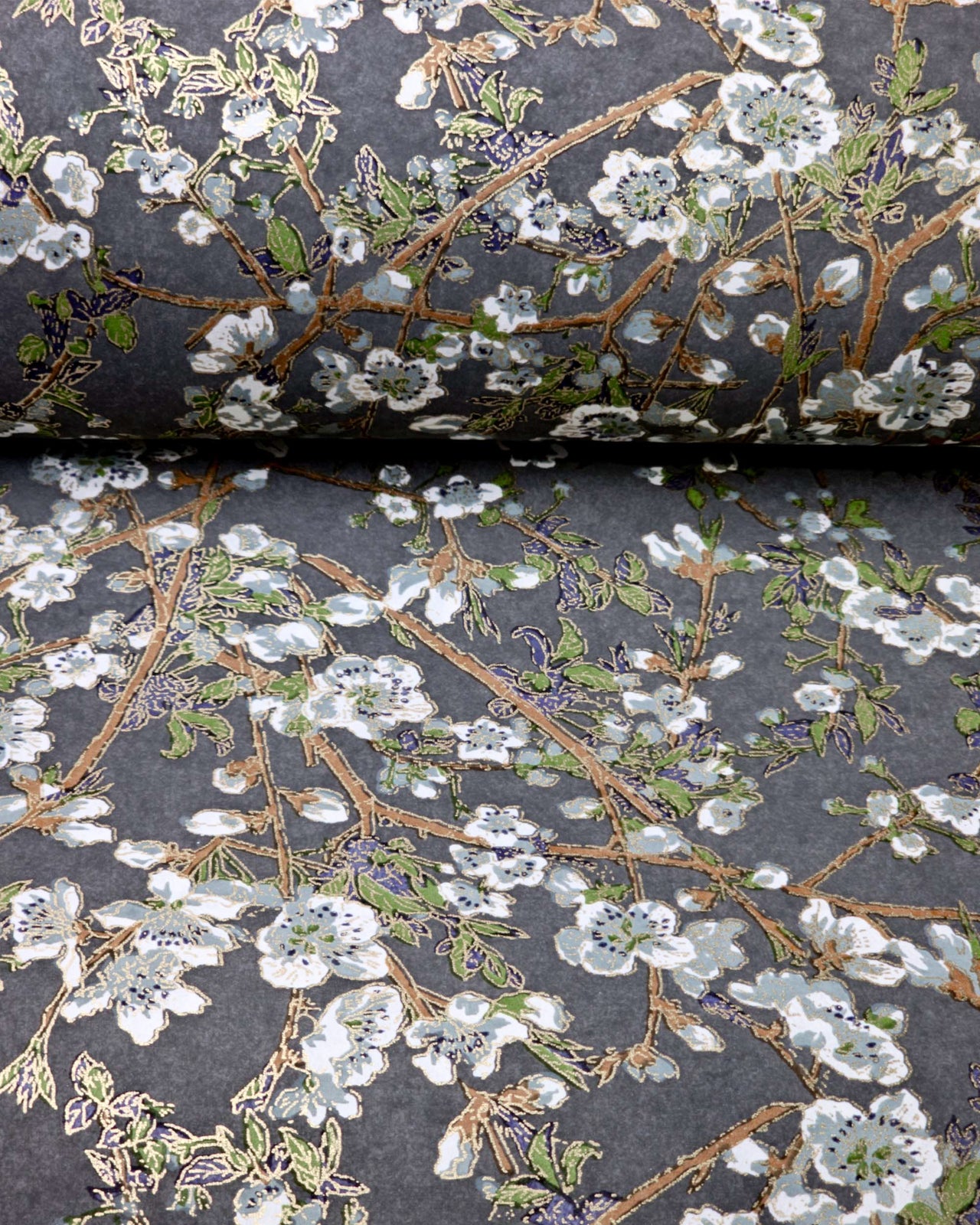 Japanese chiyogami paper featuring gray and white detailed plum blossoms with brown branches and green leaves on a dark gray background with metallic gold details.
