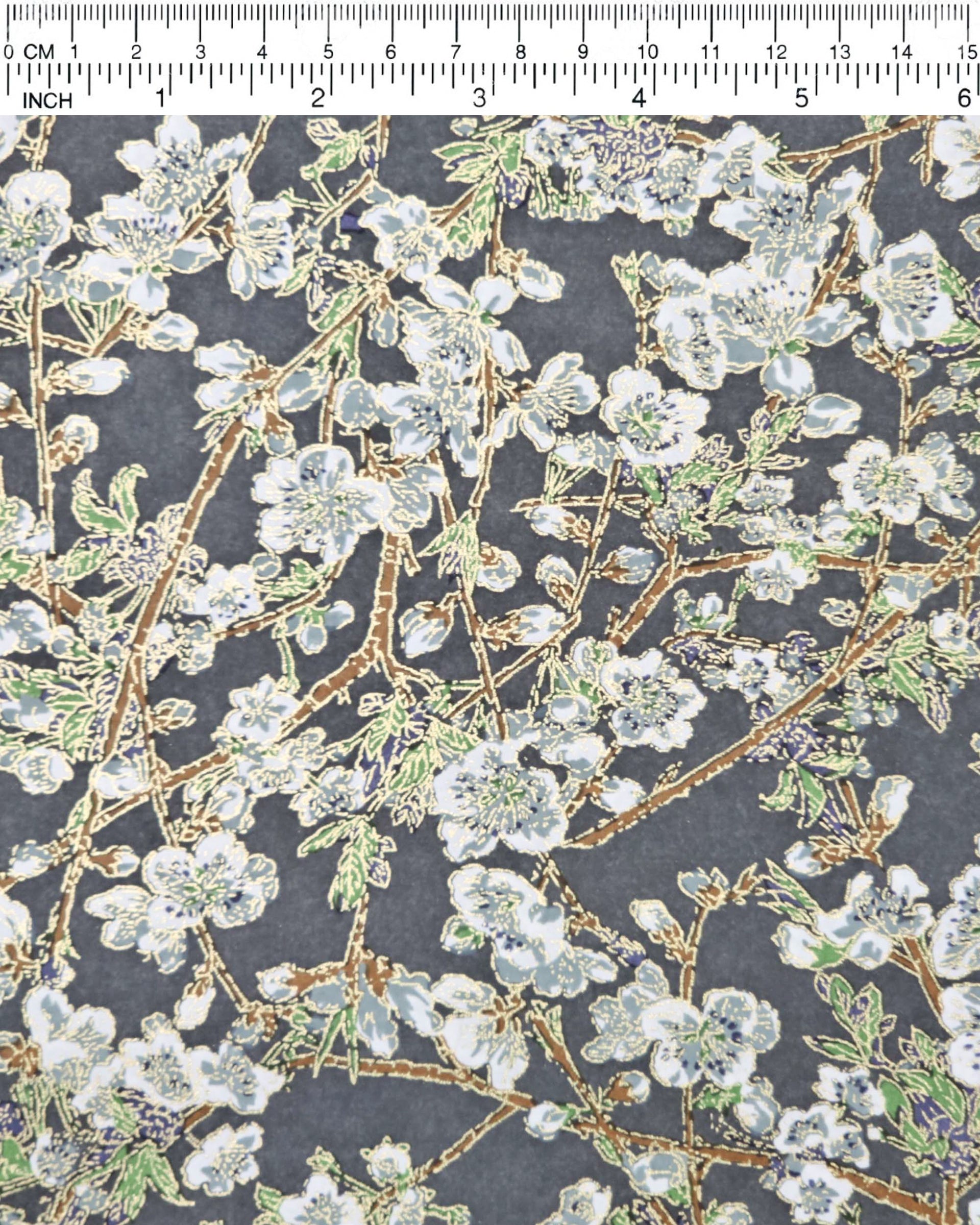 Japanese chiyogami paper featuring gray and white detailed plum blossoms with brown branches and green leaves on a dark gray background with metallic gold details.