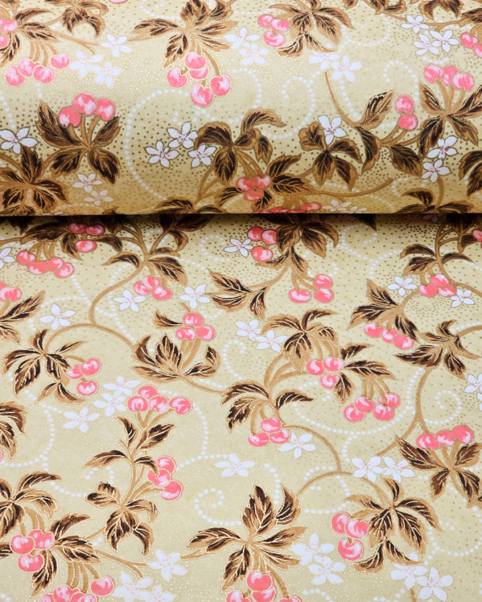Japanese chiyogami paper featuring clusters of pink cherry fruit with white flowers and brown leaves on a beige background with metallic gold details.