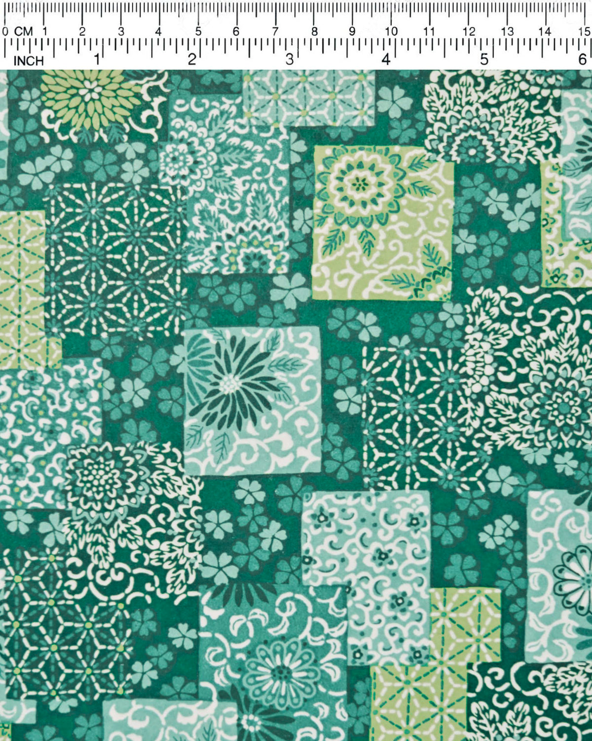 Japanese chiyogami paper featuring a patchwork-style arrangement of assorted floral and traditional Japanese patterns in various shades of green and white, shown next to a ruler for size reference.
