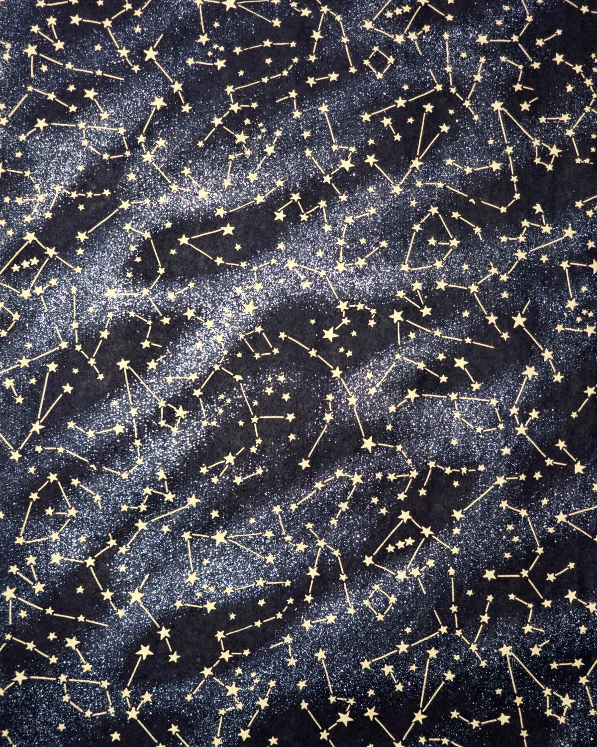 Japanese chiyogami paper featuring metallic gold stars and constellations scattered across a black background with shimmering metallic silver stardust. 