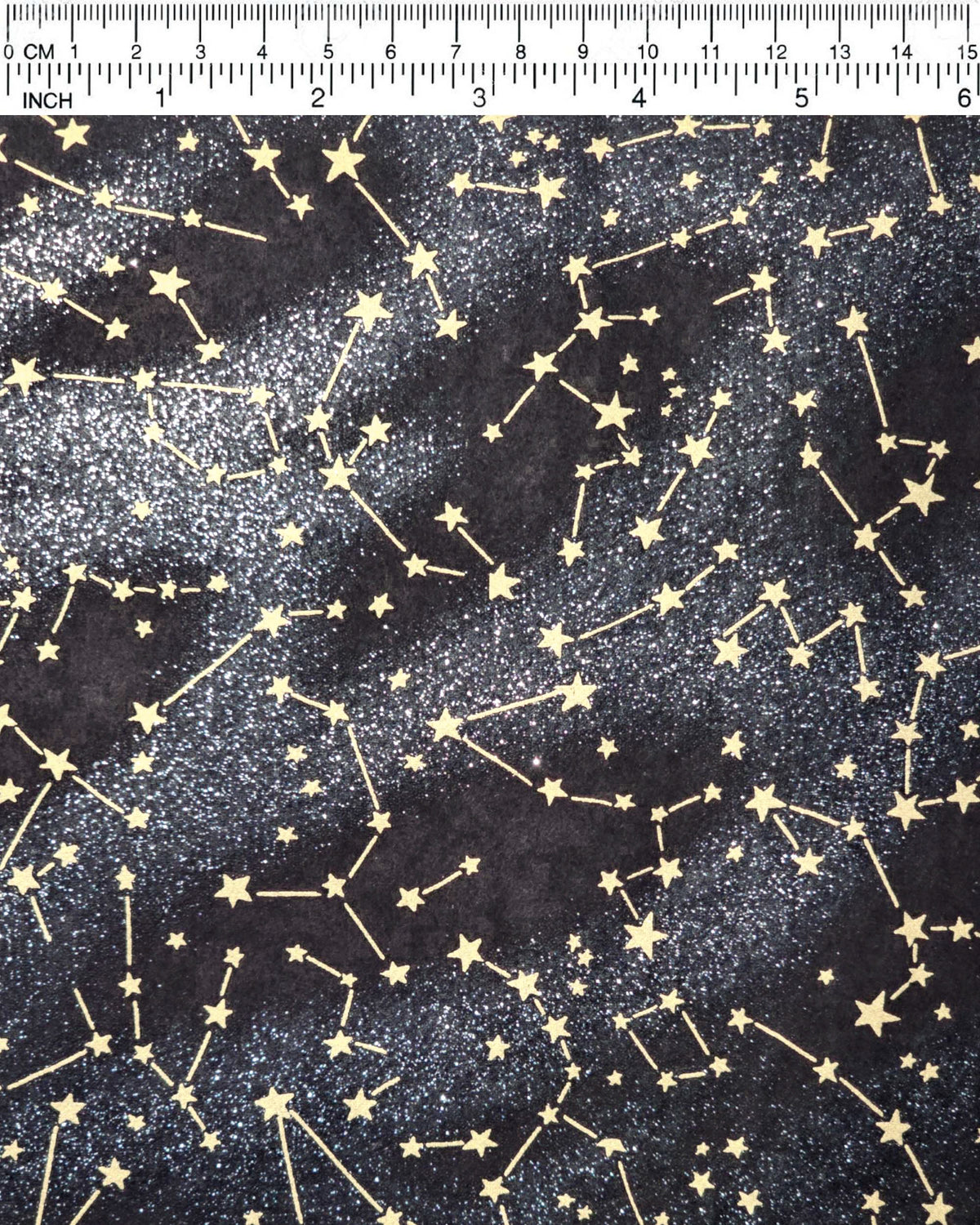 Japanese chiyogami paper featuring metallic gold stars and constellations scattered across a black background with shimmering metallic silver stardust, shown rolled to highlight the design.