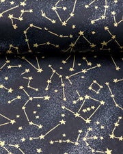 Japanese chiyogami paper featuring metallic gold stars and constellations scattered across a black background with shimmering metallic silver stardust, shown next to a ruler for size reference.