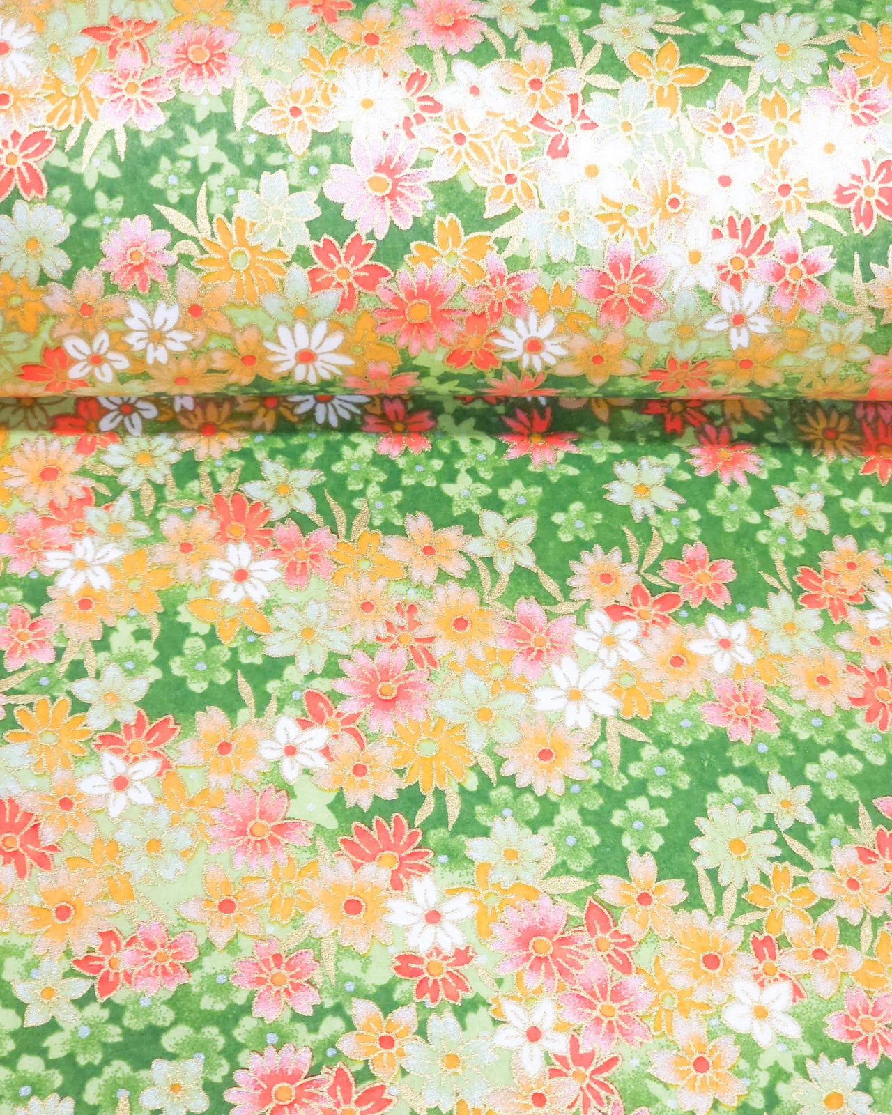 Japanese chiyogami paper featuring assorted green, white, pink, and orange flowers on a green background with metallic gold details.