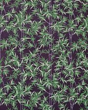 Japanese chiyogami paper featuring bamboo stalks outlined in gray with dark and light green bamboo leaves on a black background. 