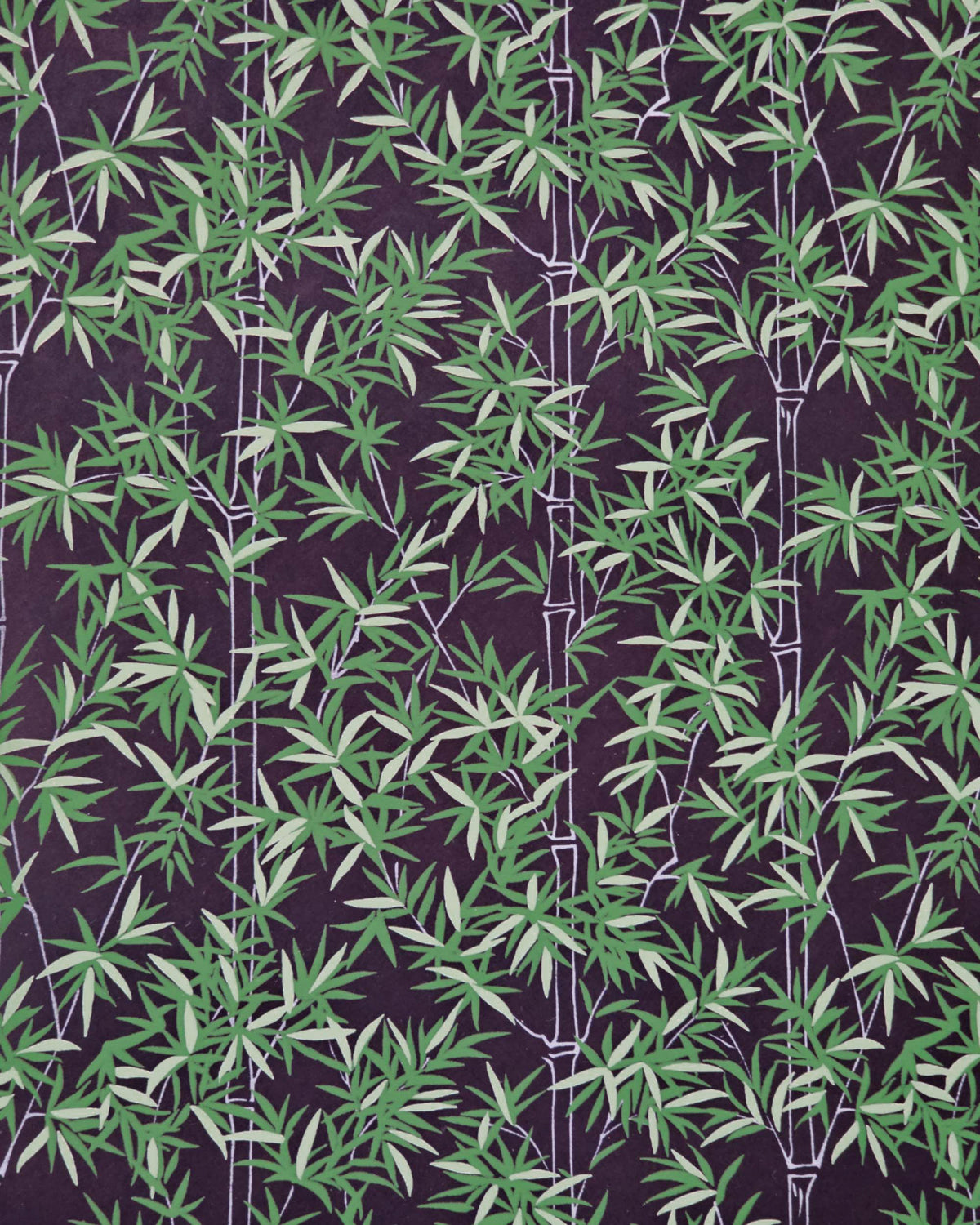 Japanese chiyogami paper featuring bamboo stalks outlined in gray with dark and light green bamboo leaves on a black background. 