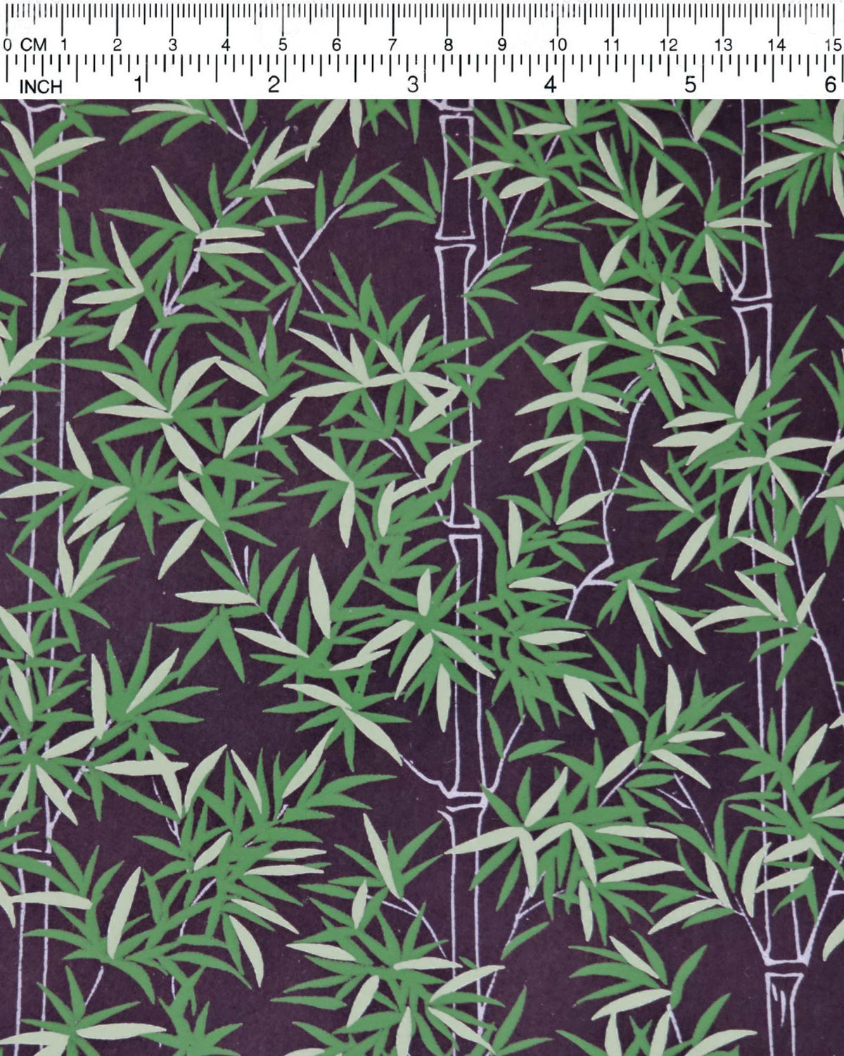 Japanese chiyogami paper featuring bamboo stalks outlined in gray with dark and light green bamboo leaves on a black background, shown next to a ruler for size reference.