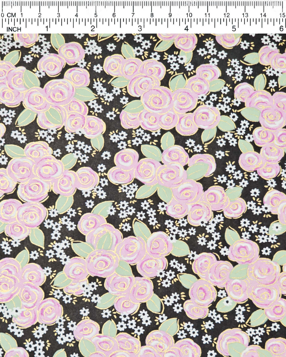 Japanese chiyogami paper featuring purple and white roses with light green leaves and smaller white flowers on a black background with metallic gold details, shown next to a ruler for size reference.
