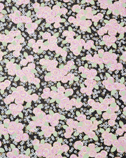Japanese chiyogami paper featuring purple and white roses with light green leaves and smaller white flowers on a black background with metallic gold details. 