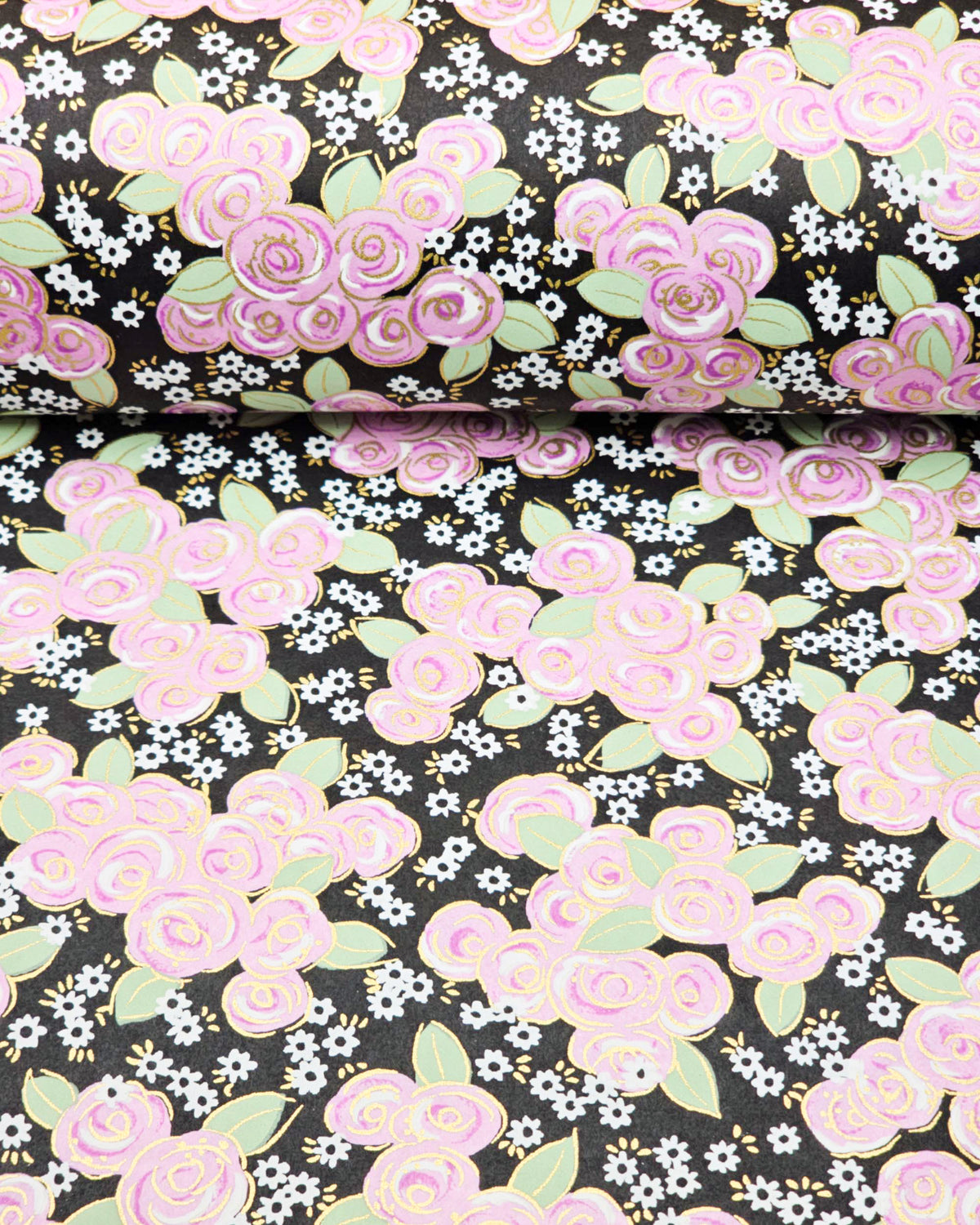 Japanese chiyogami paper featuring purple and white roses with light green leaves and smaller white flowers on a black background with metallic gold details, shown rolled to highlight the design.