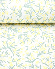Japanese chiyogami paper featuring pale yellow and white tulips with light green leaves on a white background, shown rolled to highlight the design.