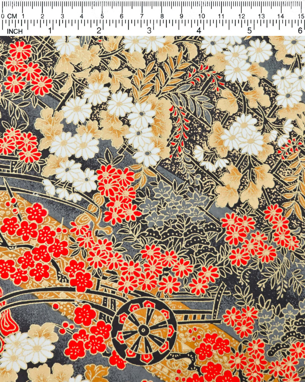 Japanese chiyogami paper featuring black flower carts with assorted red, white, and gray flowers with brown leaves on a gray background with metallic gold details, shown next to a ruler for size reference.