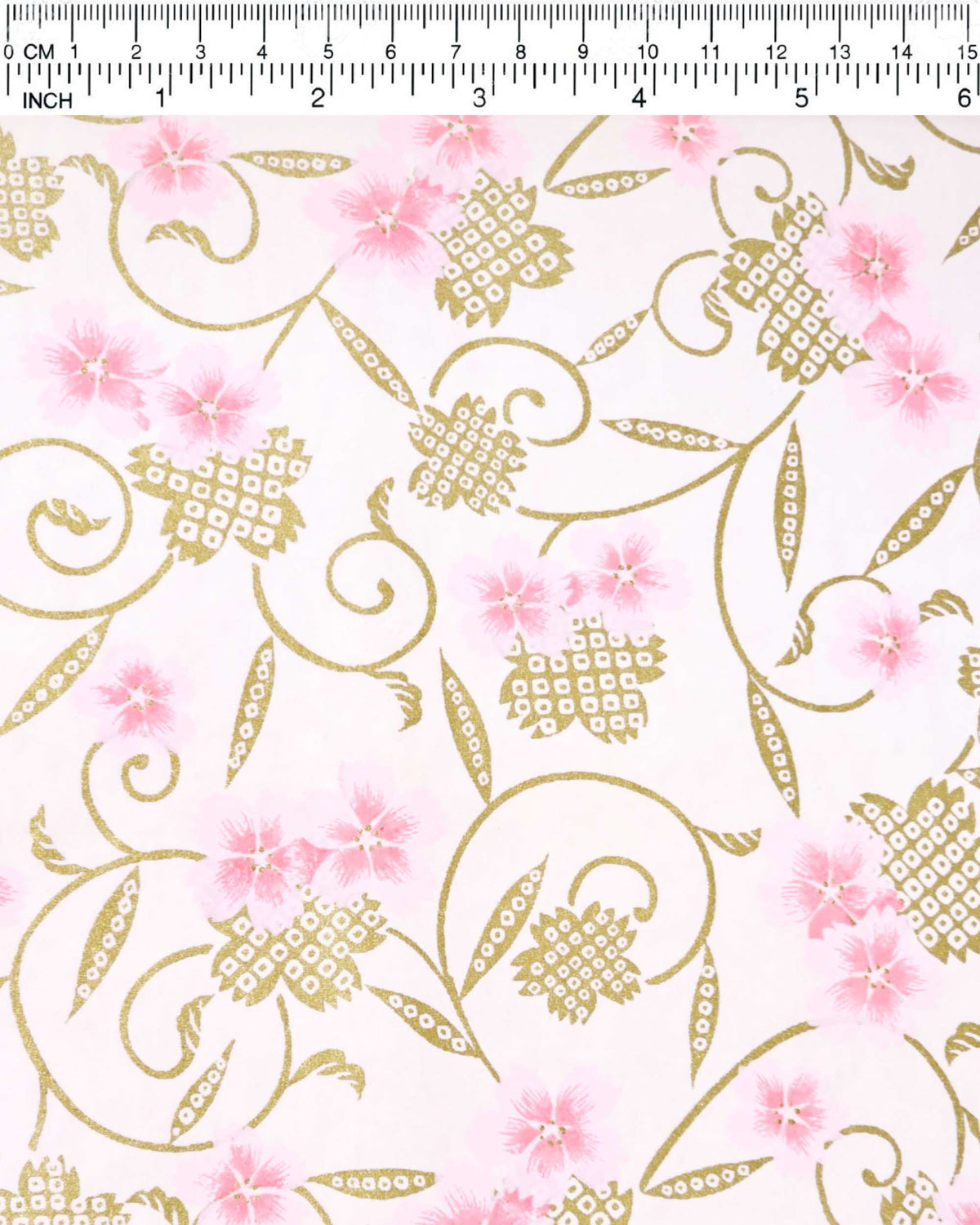 Japanese chiyogami paper featuring pink cherry blossoms alongside gold cherry blossoms and leaves decorated with a traditional kanoko (fawn) pattern on a light pink background, shown next to a ruler for size reference.
