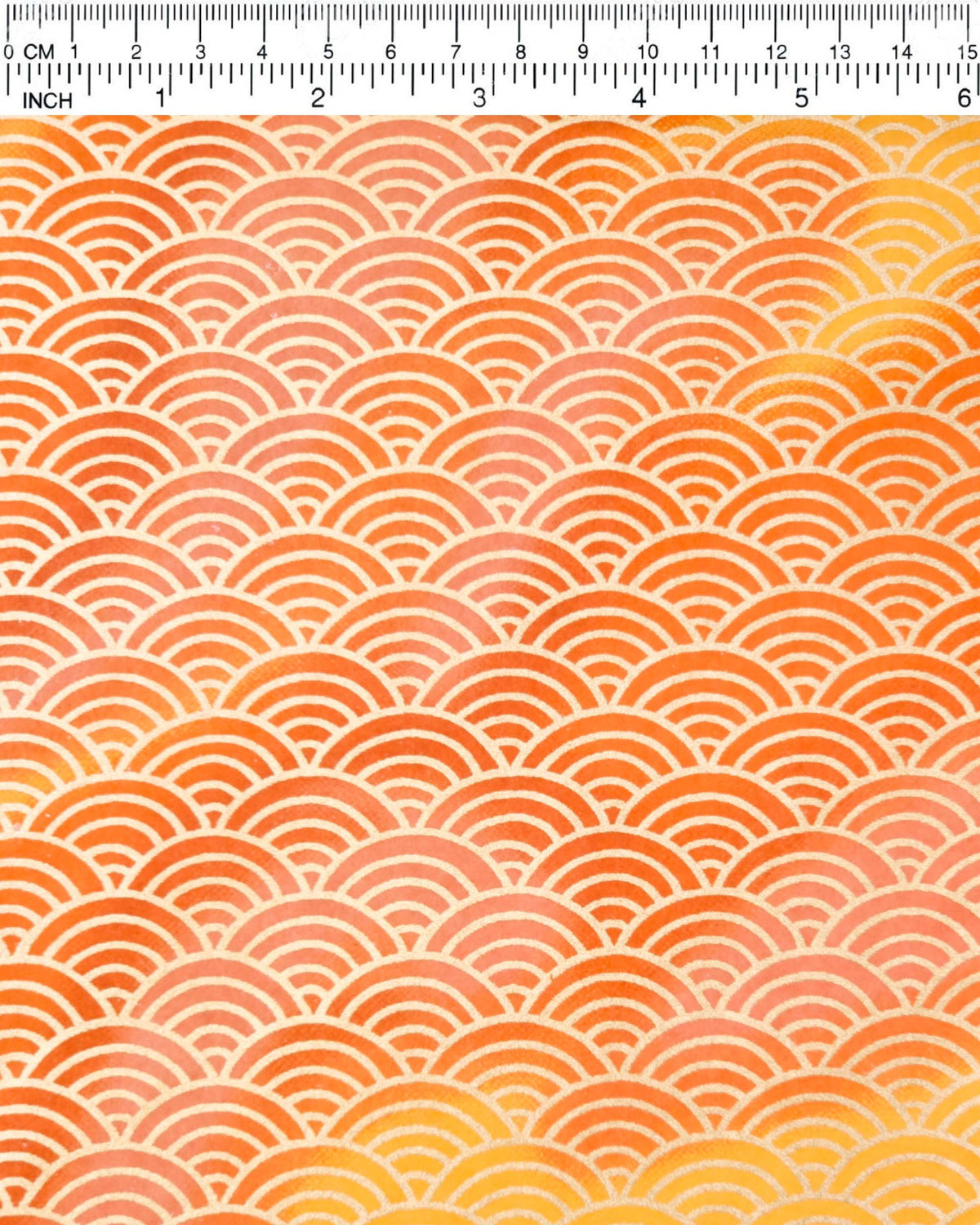 Japanese chiyogami paper featuring a large metallic gold traditional seigaiha (wave crest) pattern on a flowing background in various shades of orange, shown rolled to highlight the design.