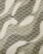 Japanese chiyogami paper featuring a large metallic gold traditional seigaiha (wave crest) pattern on a flowing background in various shades of gray and black. 