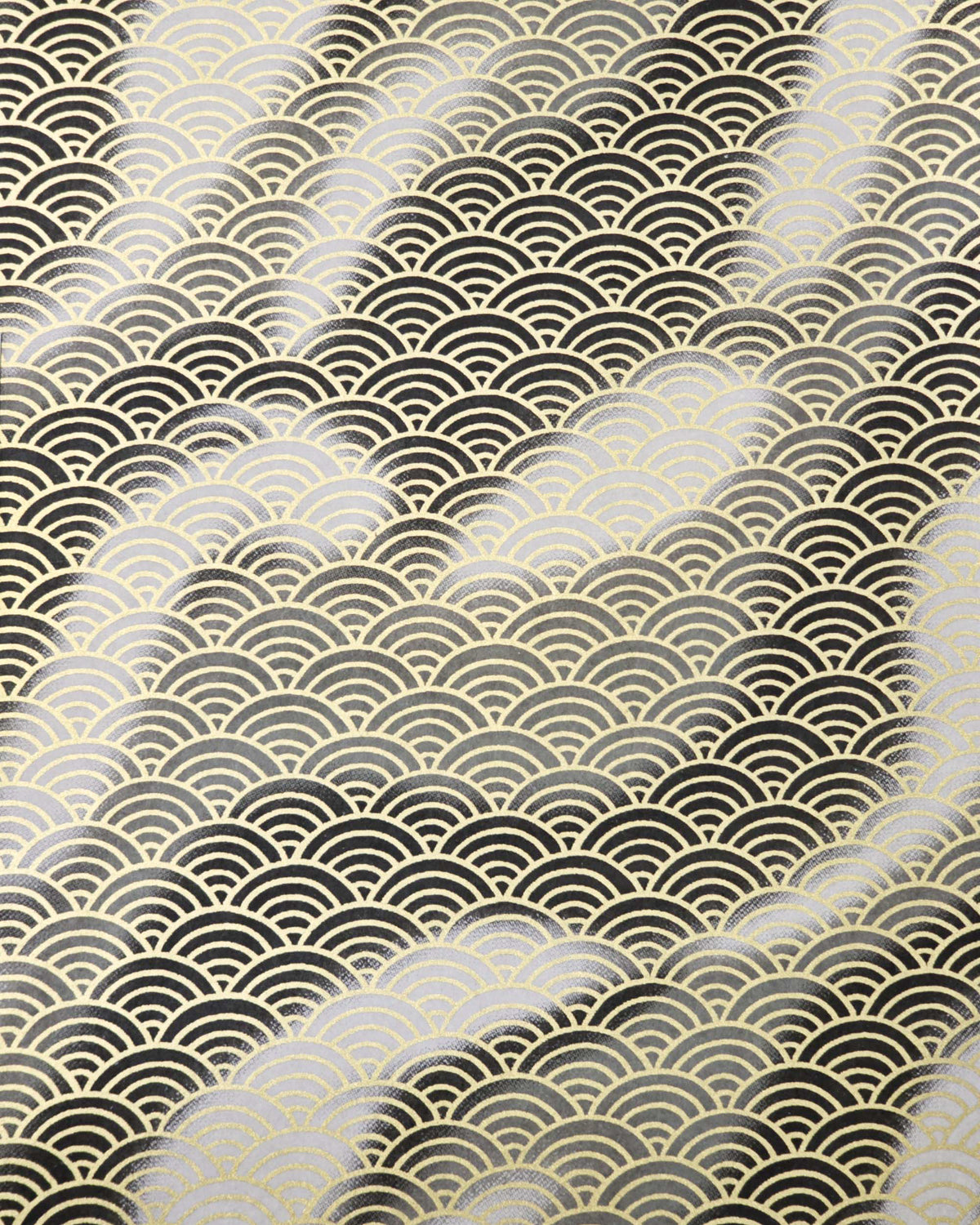 Japanese chiyogami paper featuring a large metallic gold traditional seigaiha (wave crest) pattern on a flowing background in various shades of gray and black. 