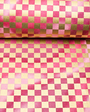 Japanese chiyogami paper featuring a large metallic gold traditional ichimatsu (checker) pattern on a flowing background in various shades of magenta pink, shown rolled to highlight the design.