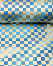 Japanese chiyogami paper featuring a large metallic gold traditional ichimatsu (checker) pattern on a flowing background in various shades of blue, shown rolled to highlight the design.