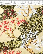 Japanese chiyogami paper featuring red and white plum and cherry blossom trees set against a metallic gold and black water ripple pattern on a gold background, shown next to a ruler for size reference.