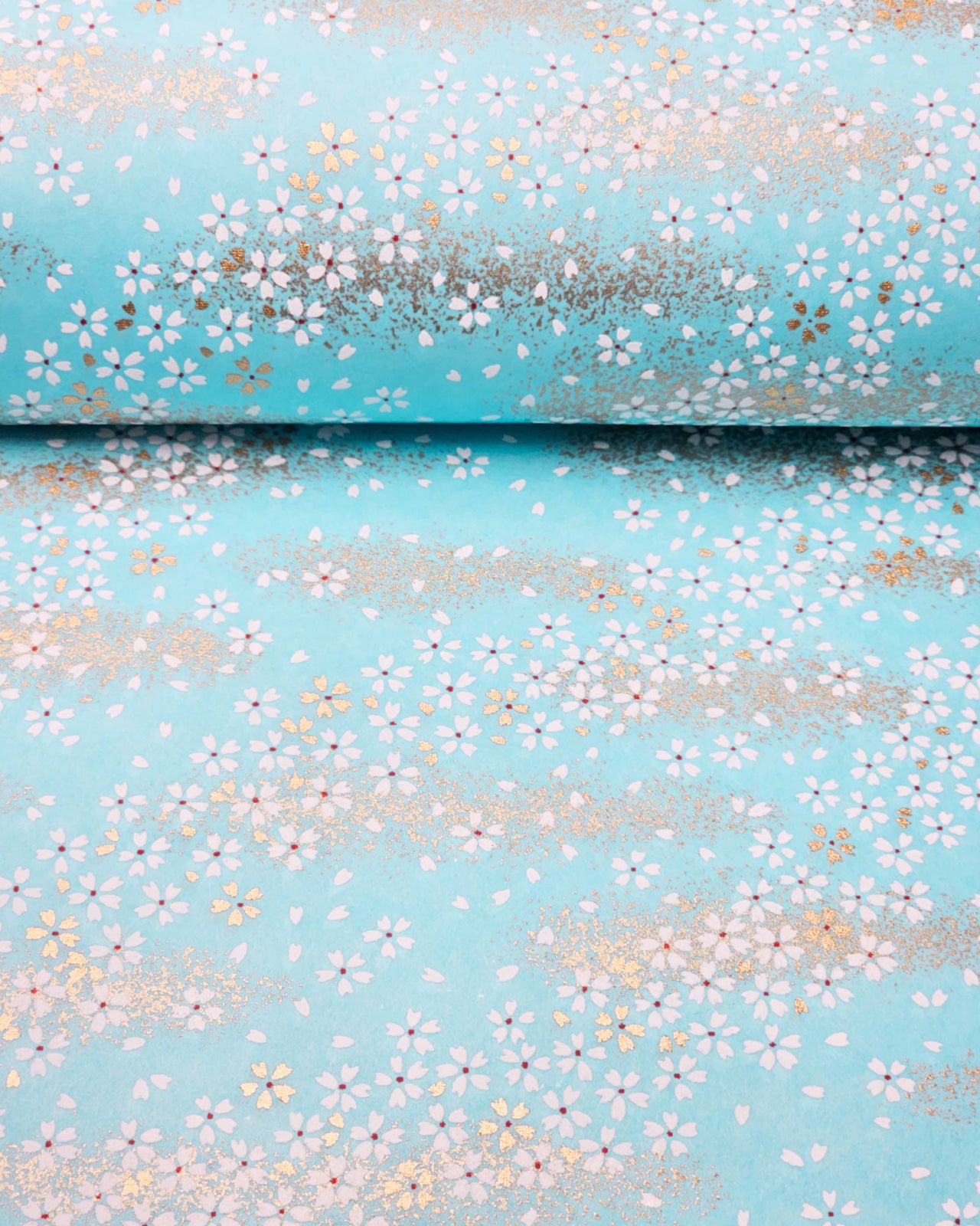 Japanese chiyogami paper featuring small white and gold cherry blossoms on an aqua blue background with metallic gold details.
