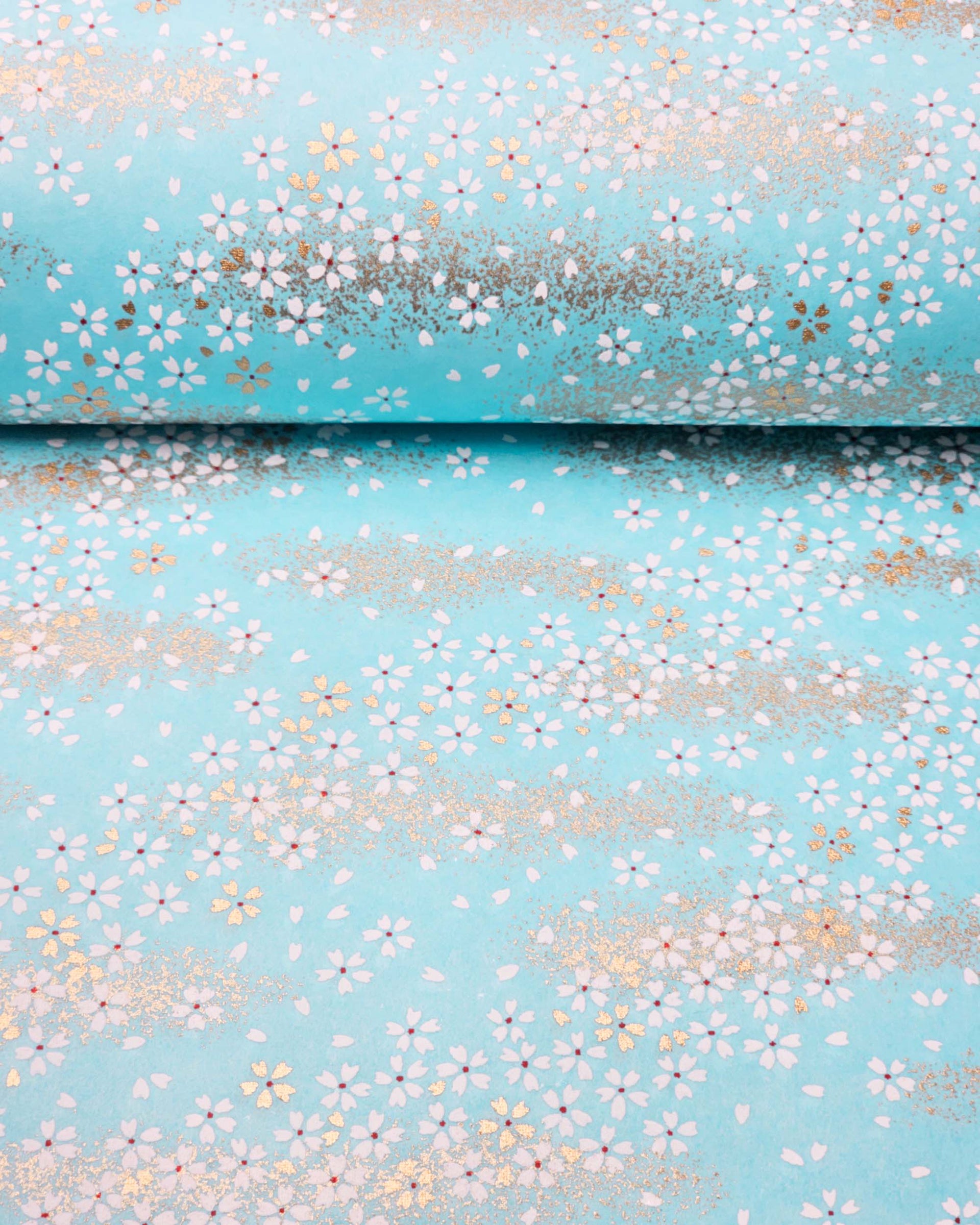 Japanese chiyogami paper featuring small white and gold cherry blossoms on an aqua blue background with metallic gold details.