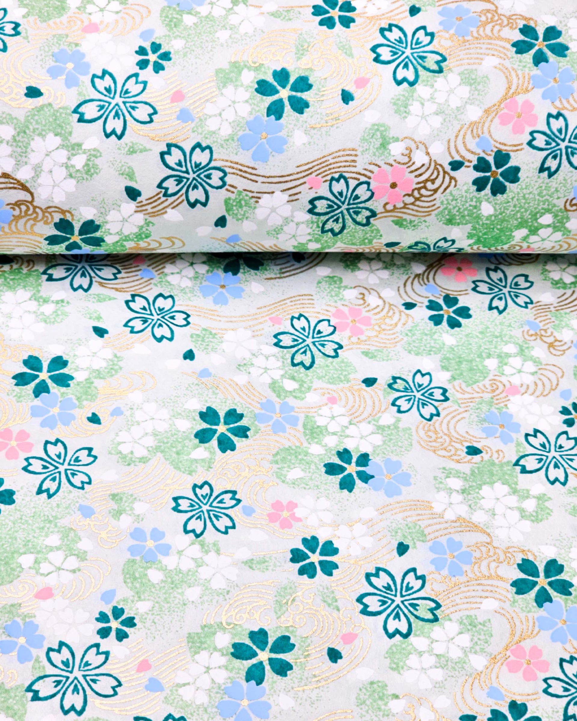 Japanese chiyogami paper featuring green, white, blue, and pink cherry blossoms on a green background with metallic gold details.