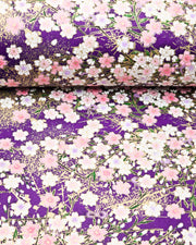 Japanese chiyogami paper featuring light pink and white cherry blossoms on a dark purple background with metallic gold details.