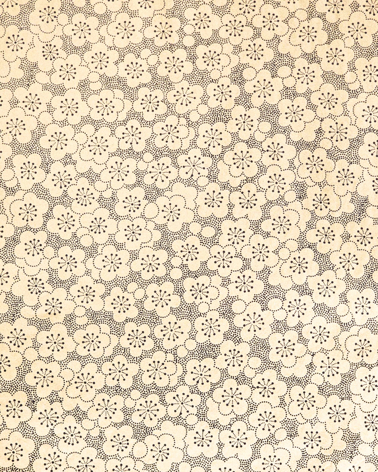 Japanese chiyogami paper featuring black pointillistic plum blossoms on a metallic gold background.