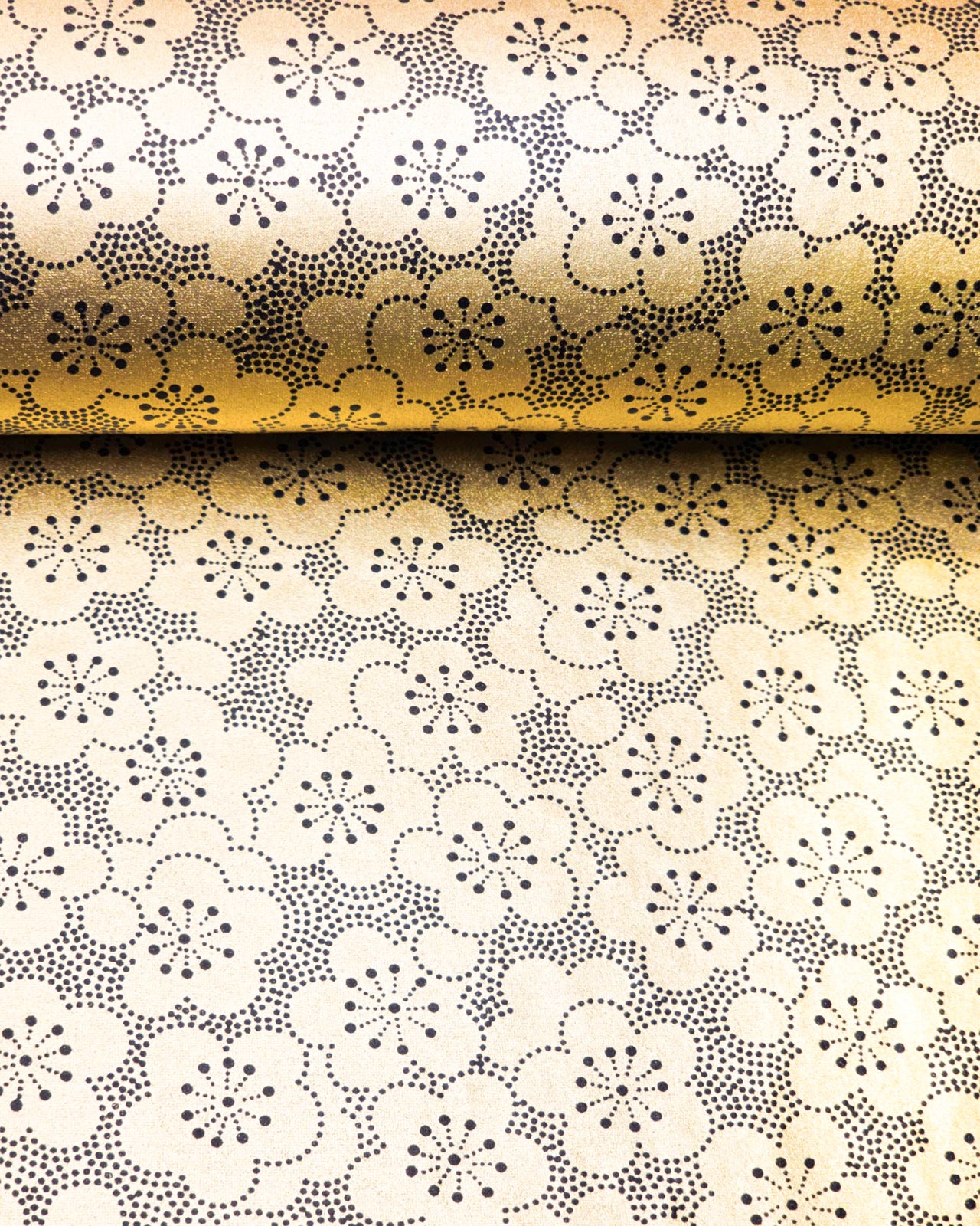 Japanese chiyogami paper featuring black pointillistic plum blossoms on a metallic gold background.