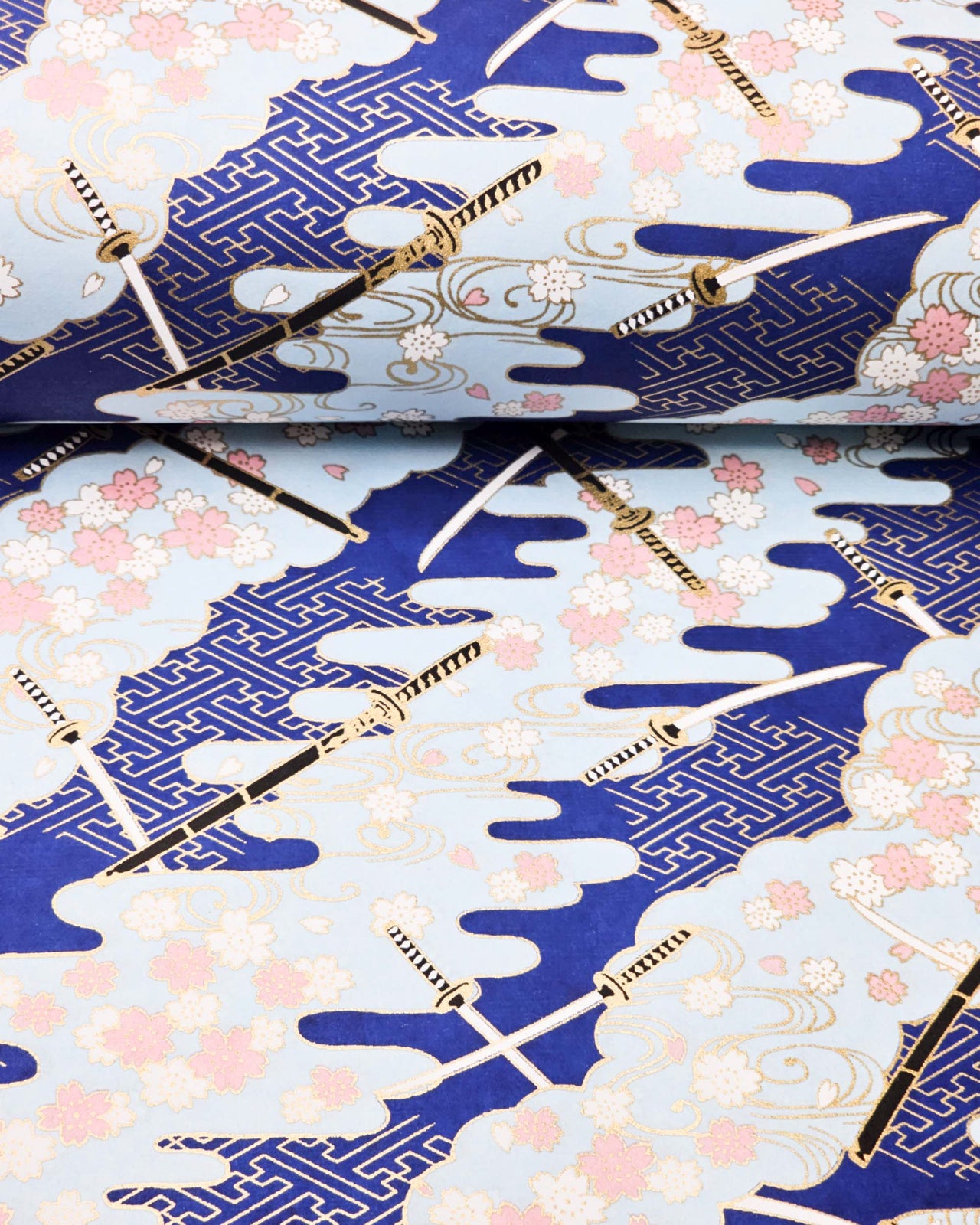 Japanese chiyogami paper featuring black and white katana swords with white and light pink cherry blossoms on a blue background with metallic gold details.