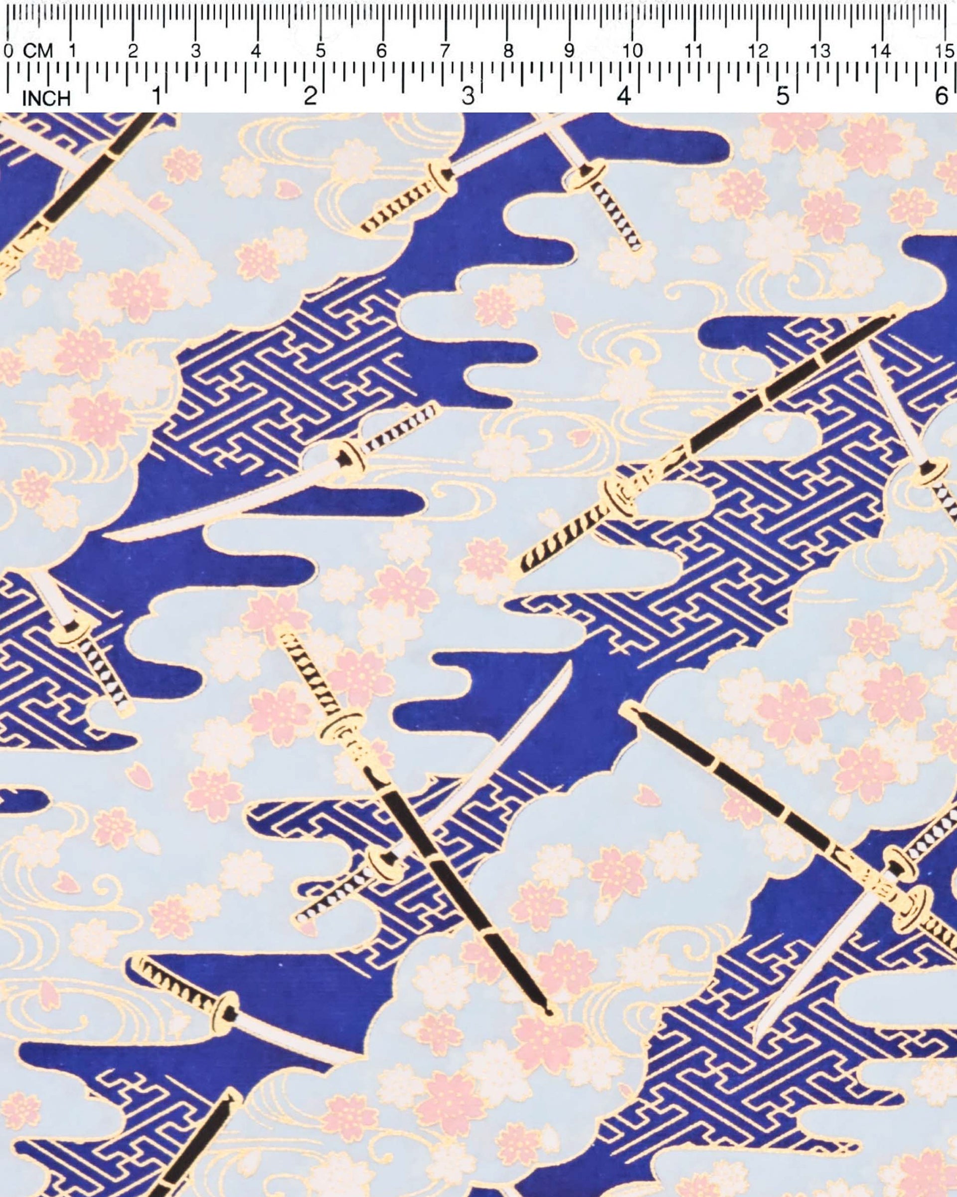 Japanese chiyogami paper featuring black and white katana swords with white and light pink cherry blossoms on a blue background with metallic gold details.