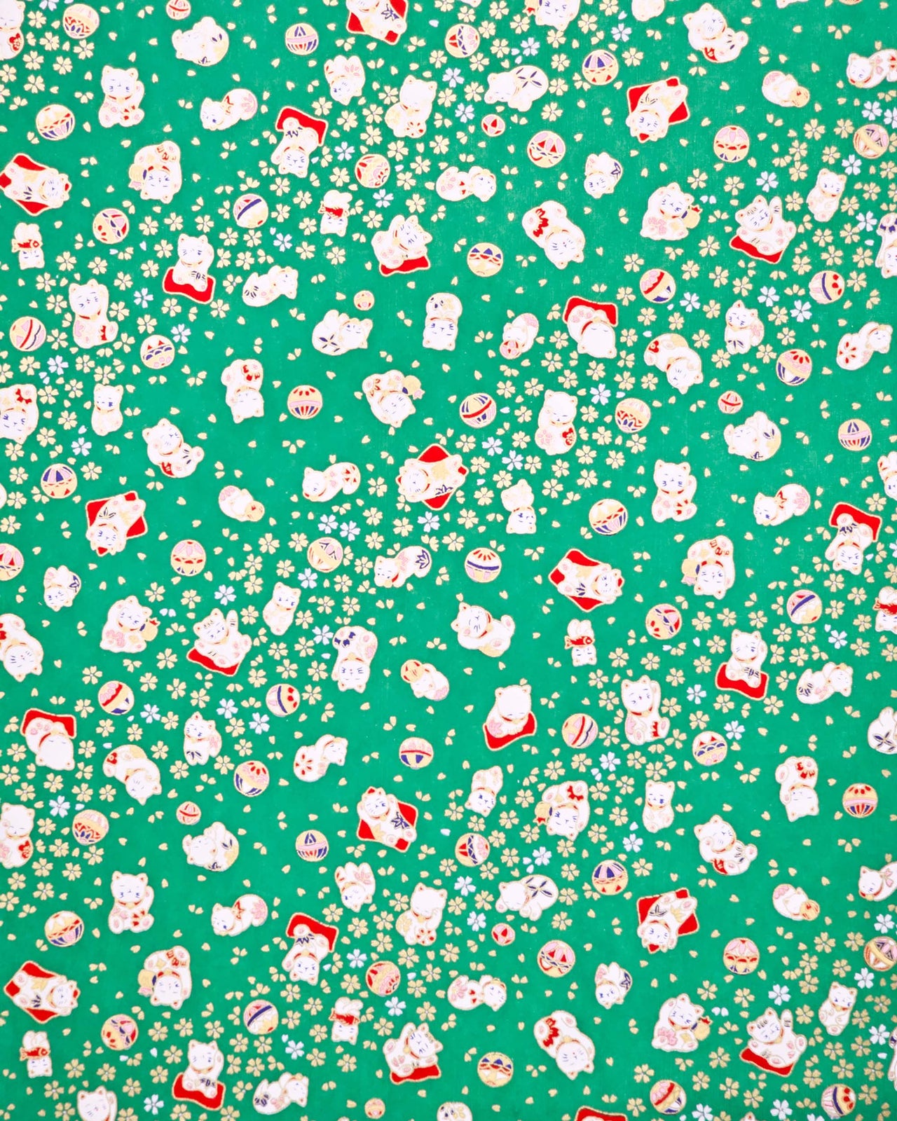 Japanese chiyogami paper featuring assorted white and red Maneki Neko (lucky cats) with small white and gold cherry blossoms and temari balls on a green background with metallic gold details.
