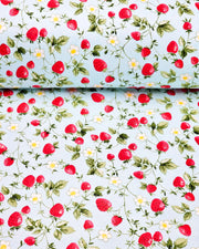 Japanese chiyogami paper featuring red strawberries with green leaves and white flowers with yellow centers on a light blue background. 