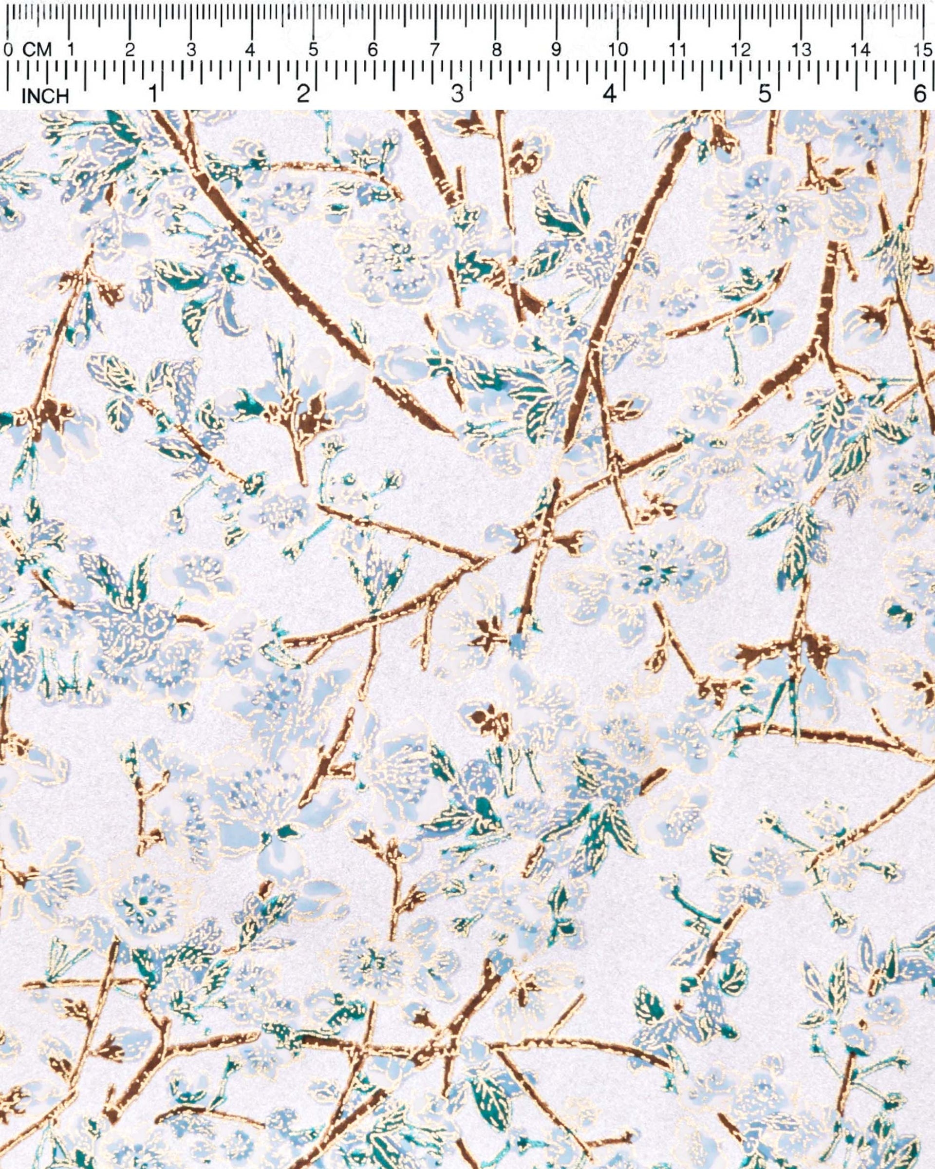 Japanese chiyogami paper featuring light blue and white plum blossoms with dark brown branches and green leaves on a metallic silver background with metallic gold details.