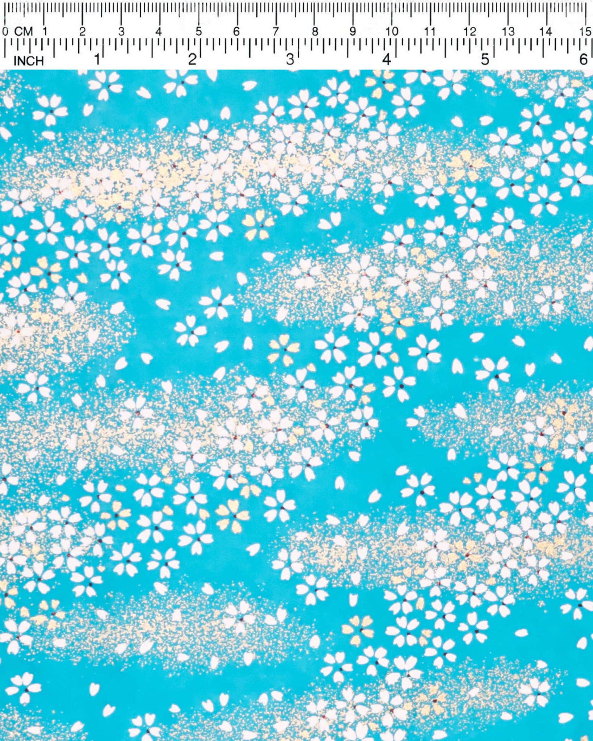 Japanese chiyogami paper featuring small white and gold cherry blossoms on a turquoise blue background with metallic gold details.