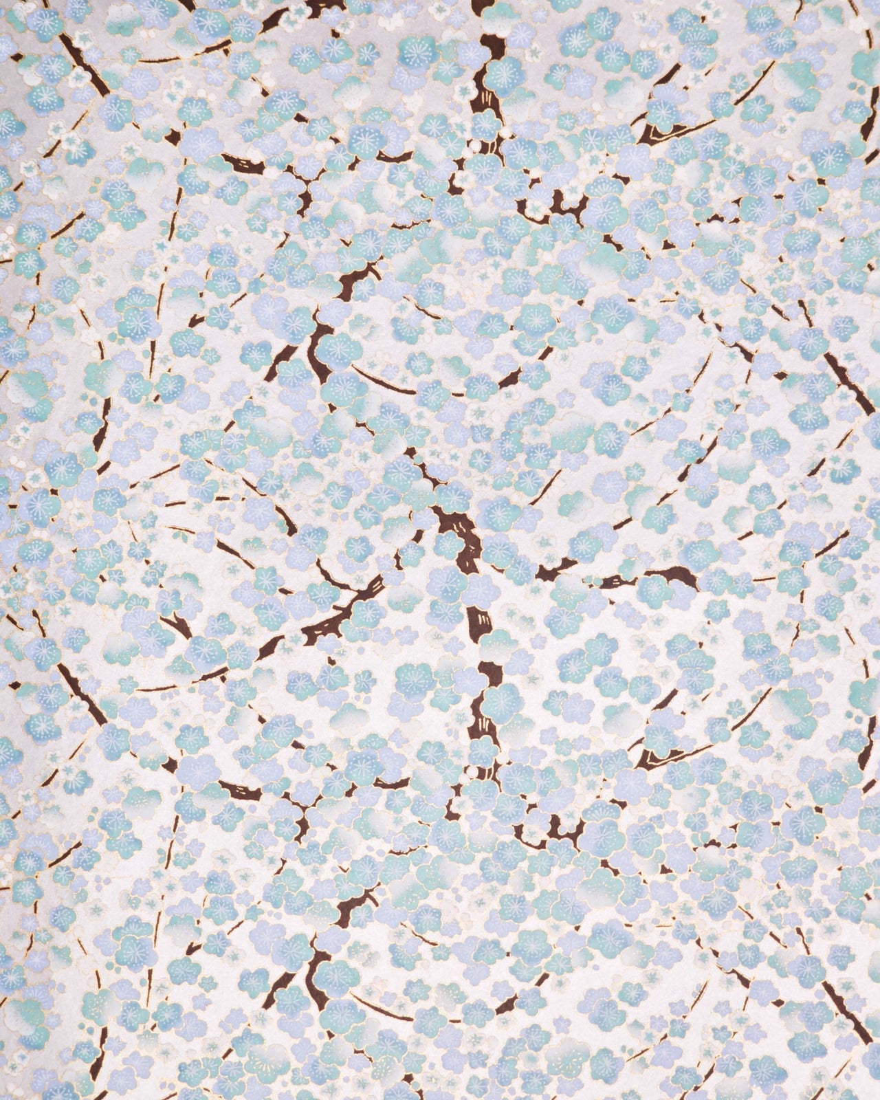 Japanese chiyogami paper featuring light turquoise and white plum blossom trees with brown branches on a silver background with metallic gold details.