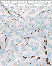 Japanese chiyogami paper featuring light turquoise and white plum blossom trees with brown branches on a silver background with metallic gold details.