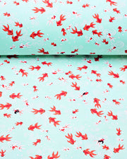 Japanese chiyogami paper featuring red orange and white koi fishes on a turquoise blue background with white water ripples.