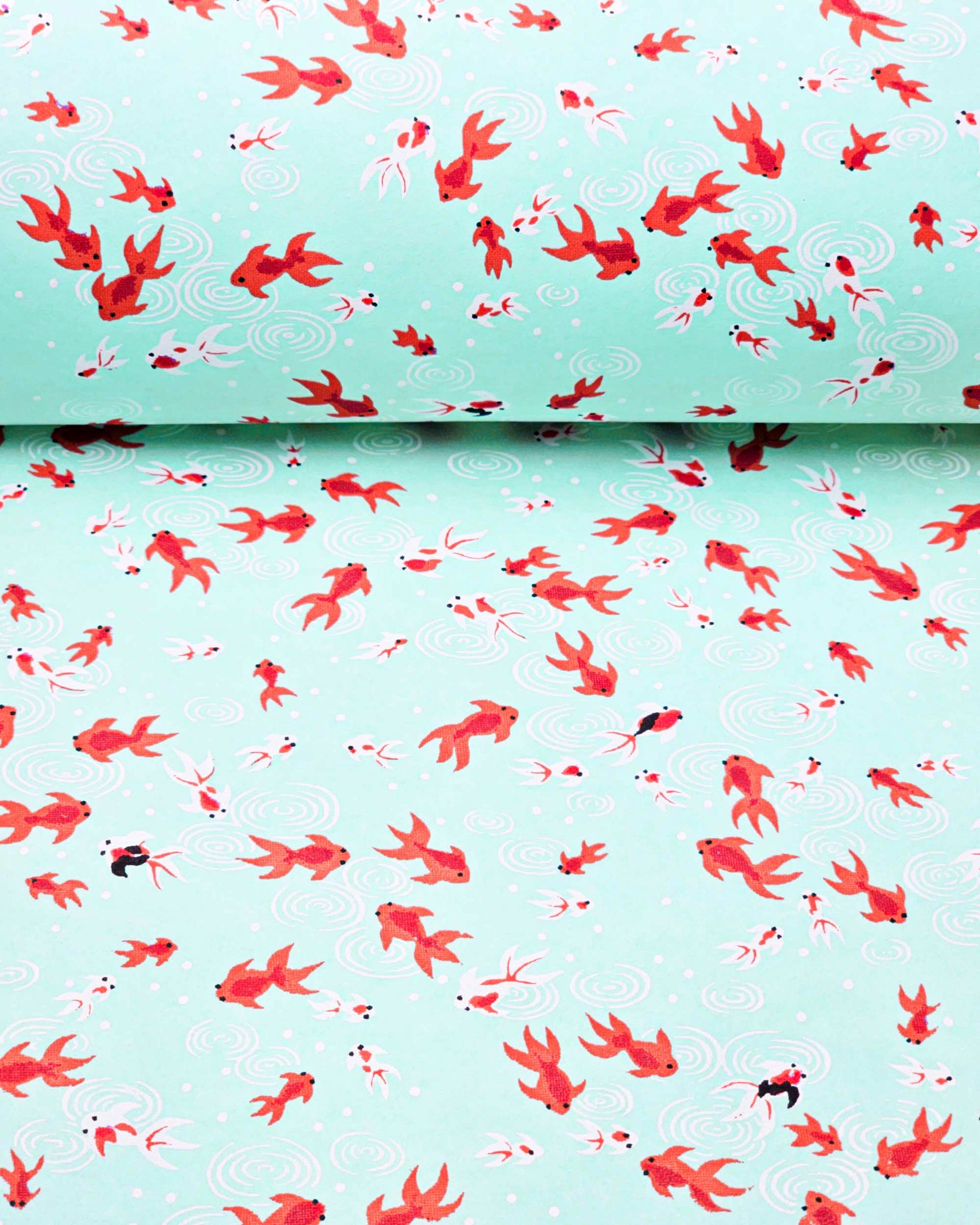 Japanese chiyogami paper featuring red orange and white koi fishes on a turquoise blue background with white water ripples.