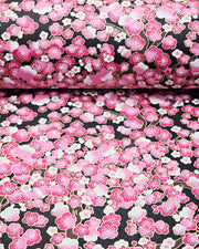 Japanese chiyogami paper featuring pink and white plum blossom trees with brown branches on a black background with metallic gold details.
