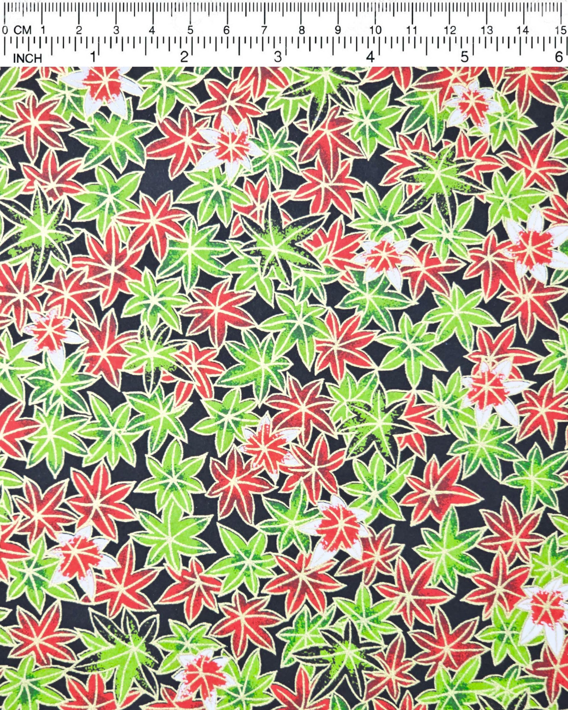 Japanese chiyogami paper featuring red, green, and white maples leaves on a black background with metallic gold details.