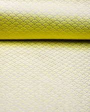 Japanese chiyogami paper featuring a small metallic gold seigaiha wave crest design on a yellow background.