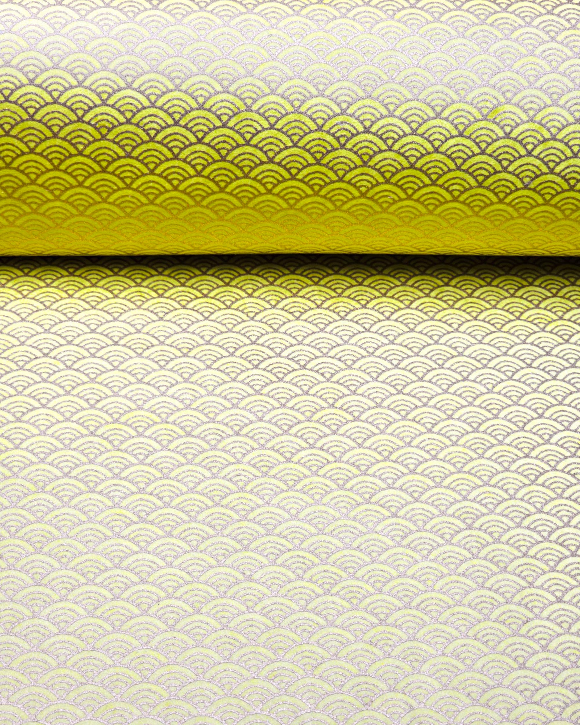 Japanese chiyogami paper featuring a small metallic gold seigaiha wave crest design on a yellow background.