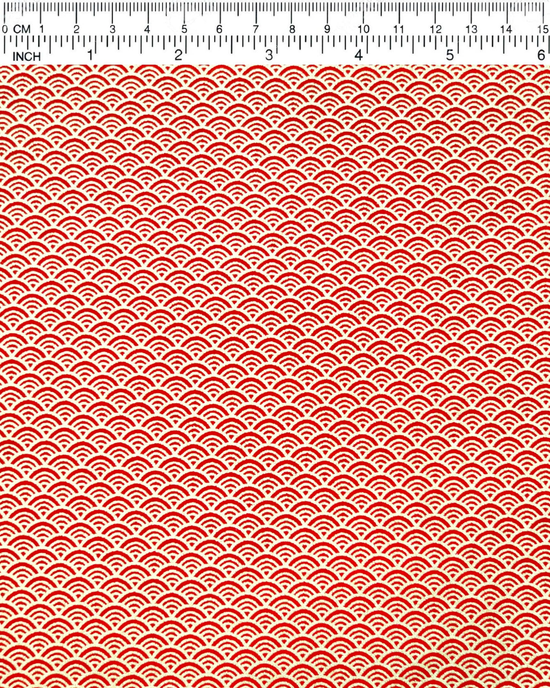 Japanese chiyogami paper featuring a small metallic gold seigaiha wave crest design on a red background.